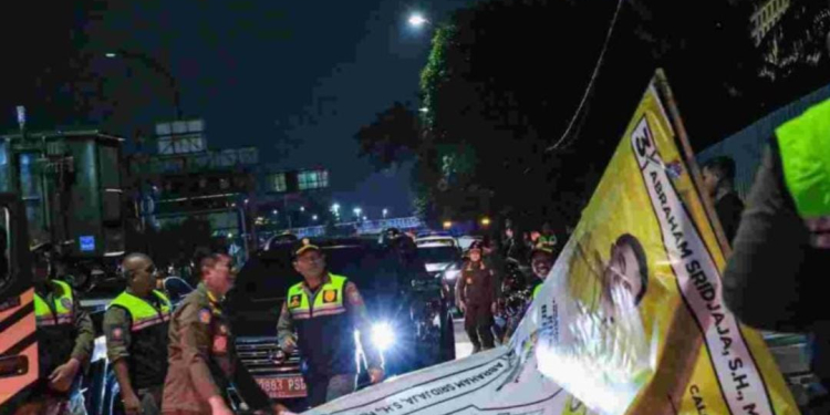 Satuan Polisi Pamong Praja (Satpol PP) Provinsi DKI Jakarta menurunkan alat peraga kampanye (APK) secara serentak di lima wilayah kota Jakarta, Minggu (11/2/2024) dini hari. (Foto: Dok. Antara/Ho/Pemerintah Provinsi DKI Jakarta)