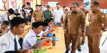 Pj Bupati Aceh Besar Muhammad Iswanto melihat menu simulasi makan siang gratis bergizi untuk pelajar di SMP Negeri 1 Darul Imarah, Aceh Besar, Selasa (5/3/2024). (Foto: Alibi/Dok. MC Aceh Besar)