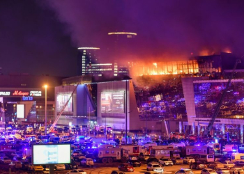 Asap membubung di atas tempat konser Crocus City Hall yang terbakar menyusul insiden penembakan di dekat Moskow, Rusia (22/3/2024). (Foto: Xinhua/Cao Yang)