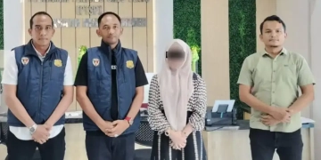 Penyidik Subdit Siber Ditreskrimsus Polda Aceh menyerahkan seorang wanita berinisial UK (19) tersangka kasus promosi judi online ke jaksa penuntut umum (JPU) Kejaksaan Negeri (Kejari) Bireuen, Kamis (25/4/2024). (Foto: Alibi/Dok. Polda Aceh)