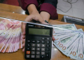 Arsip - Petugas menunjukkan angka pada kalkulator di tempat penukaran uang Dolarindo, Melawai, Jakarta. (Foto: Dok. Antara/Rivan Awal Lingga/foc)